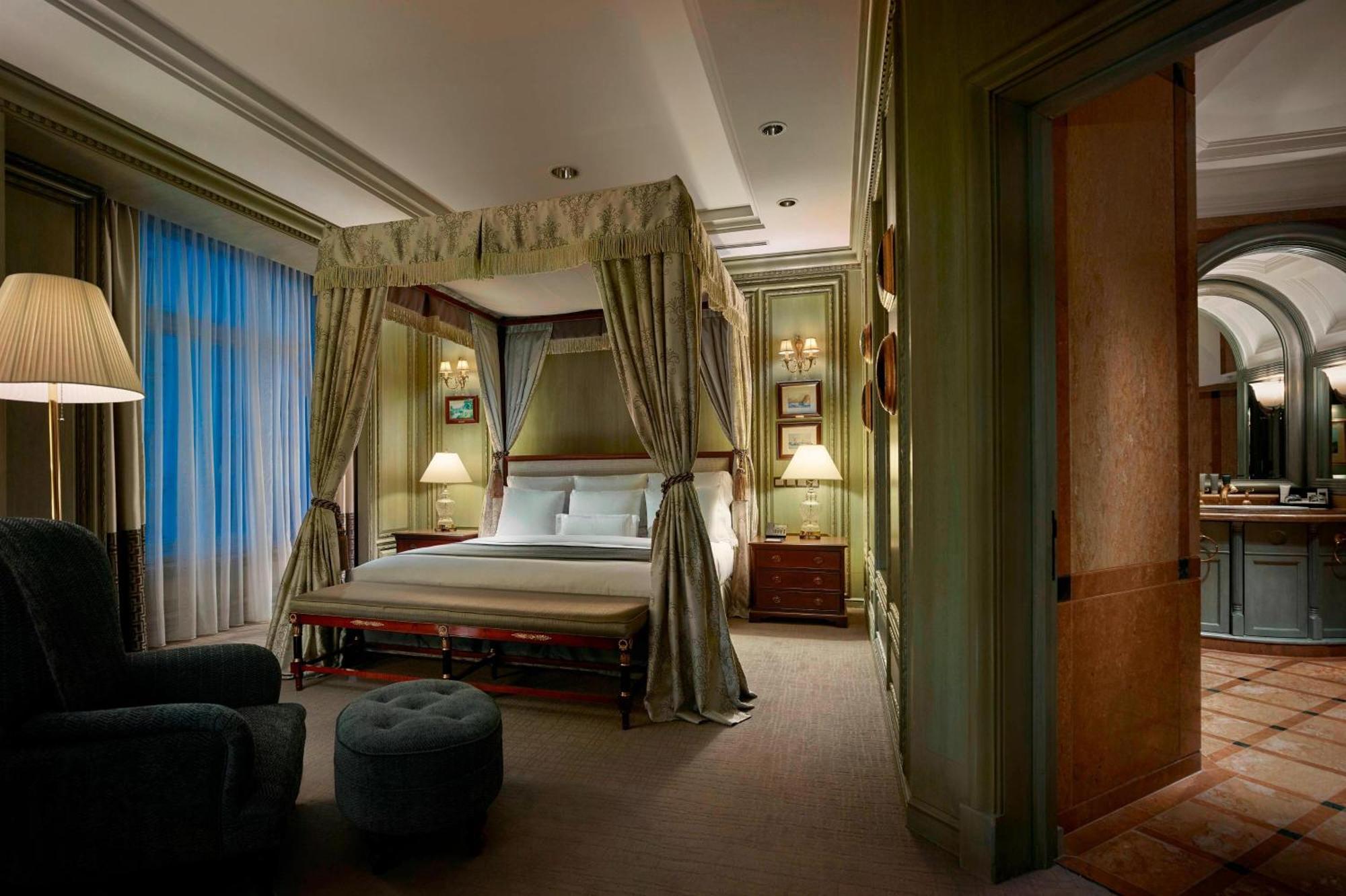 Jw Marriott Kuala Lumpur Hotel Exterior photo The photo depicts a luxurious bedroom featuring a four-poster bed draped with elegant curtains. The bed is positioned against a wall with soft, muted colors, creating a calming atmosphere. On either side of the bed, there are bedside tables with lamp