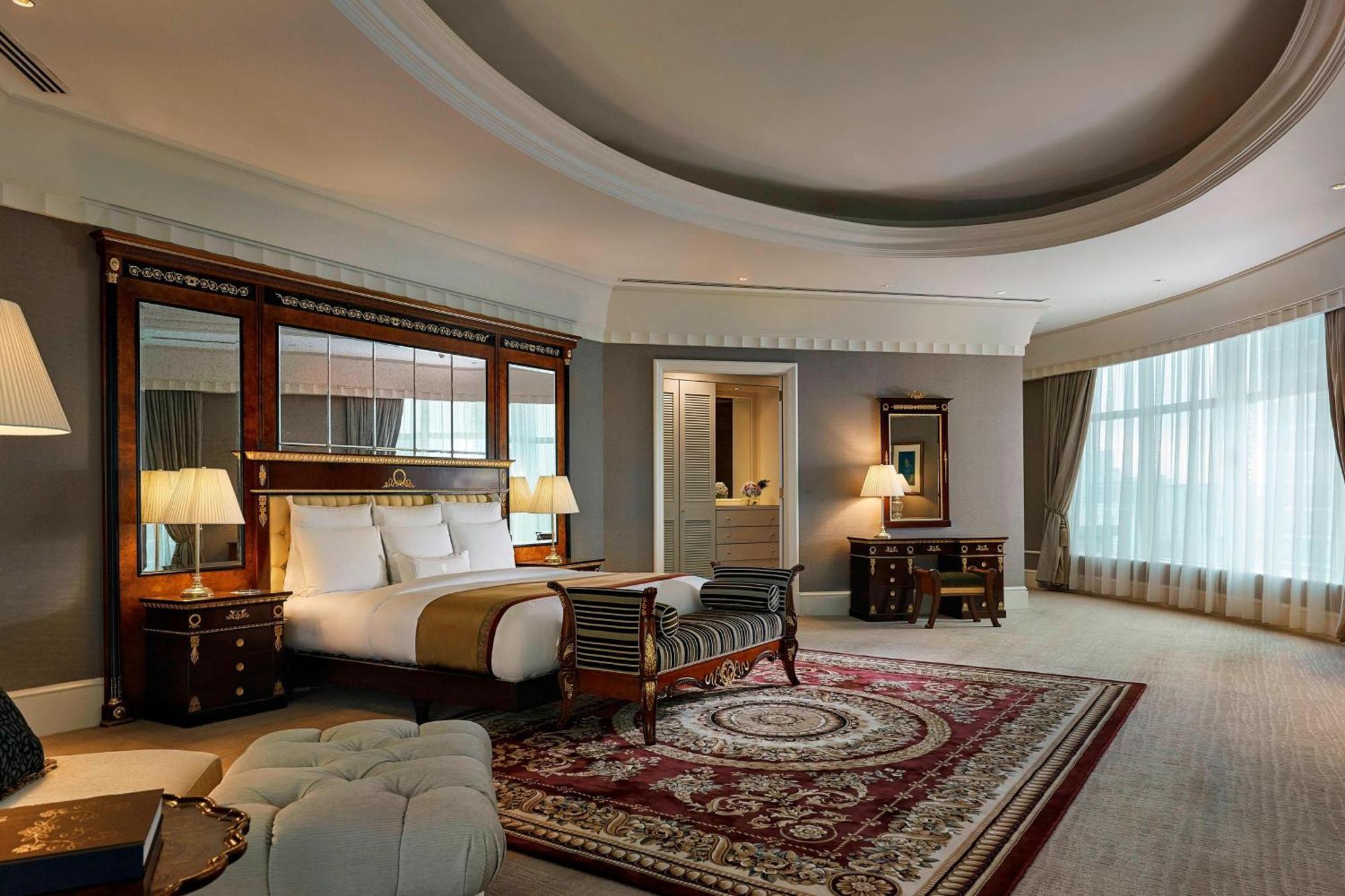 Jw Marriott Kuala Lumpur Hotel Exterior photo The photo shows an elegant hotel room with a luxurious design. It features a large king-size bed with white linens, flanked by stylish bedside lamps. There is a decorative mirror behind the bed that adds depth to the space. The room includes a plush 