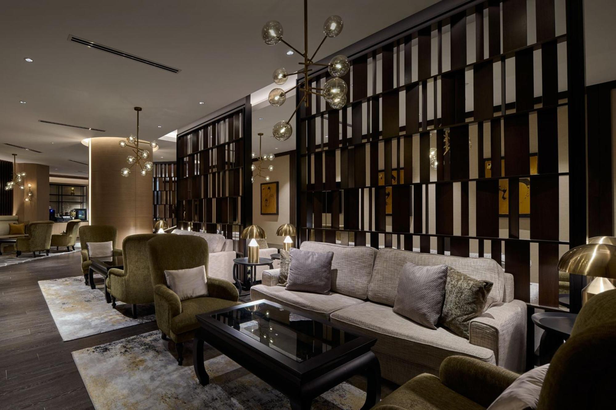 Jw Marriott Kuala Lumpur Hotel Exterior photo The photo depicts a modern and stylish lounge or living area. It features elegant furnishings, including plush sofas and armchairs in muted colors, arranged around a dark coffee table. The walls have a stylish wooden paneling design that adds a sophi