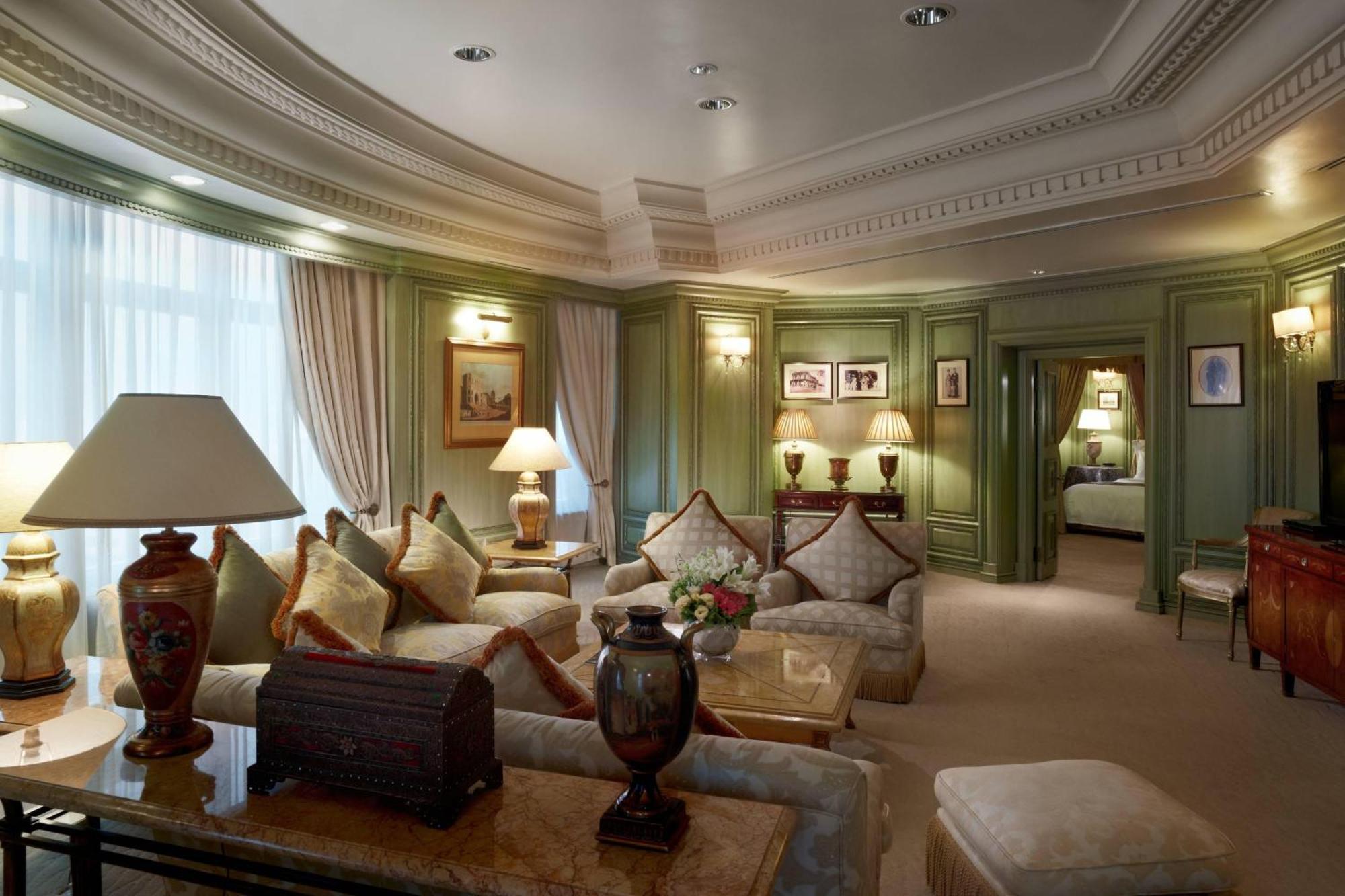Jw Marriott Kuala Lumpur Hotel Exterior photo The photo shows a luxurious living room with elegant decor. The walls are a soft green, and there are large windows allowing natural light to fill the space. The furniture includes a comfortably arranged seating area with plush sofas and decorative c
