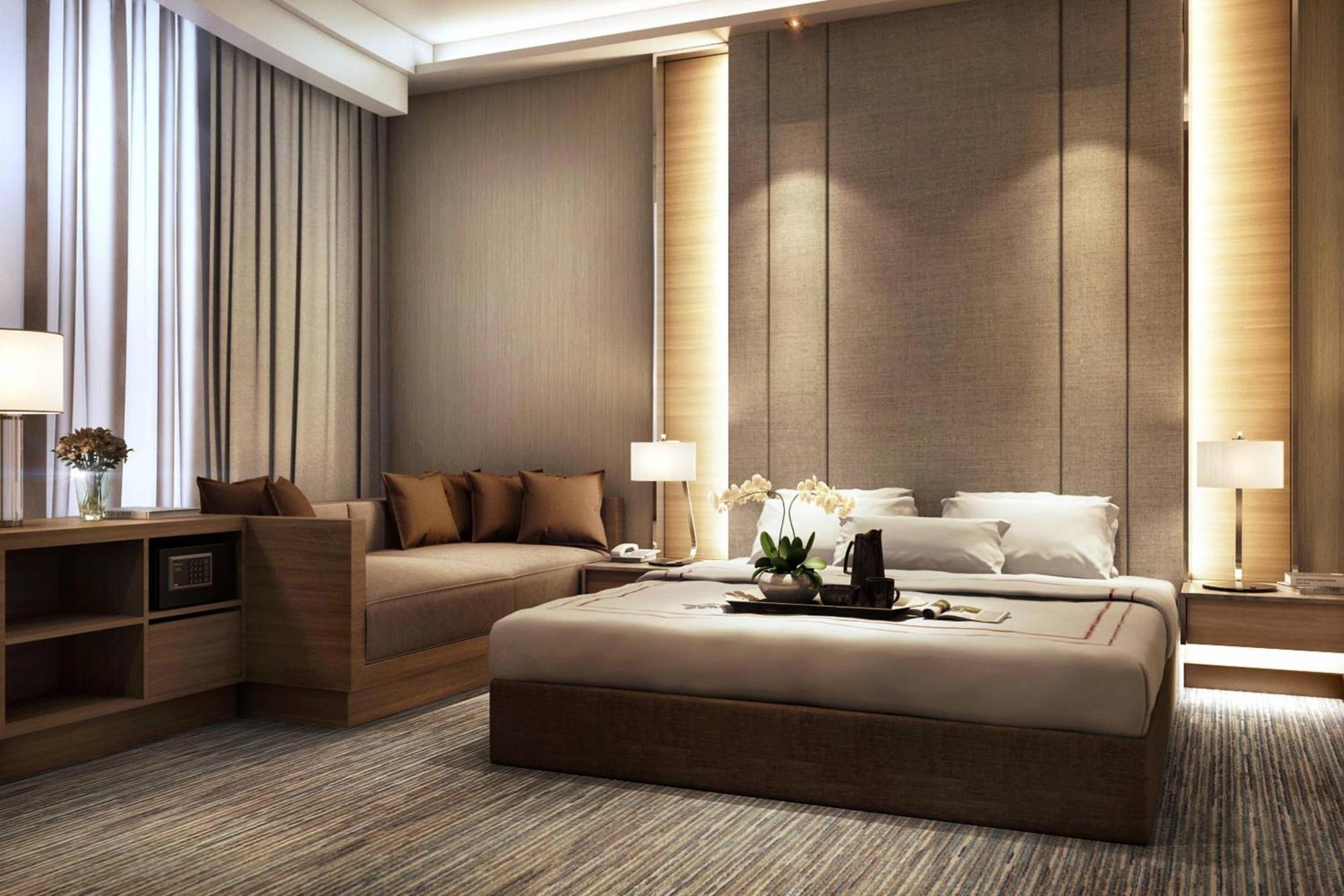 Jw Marriott Kuala Lumpur Hotel Exterior photo The photo depicts a modern and stylish bedroom. It features a large bed with neutral-colored bedding and an elegant headboard. On either side of the bed, there are bedside tables with contemporary lamps. There's a cozy seating area with a sofa adorne