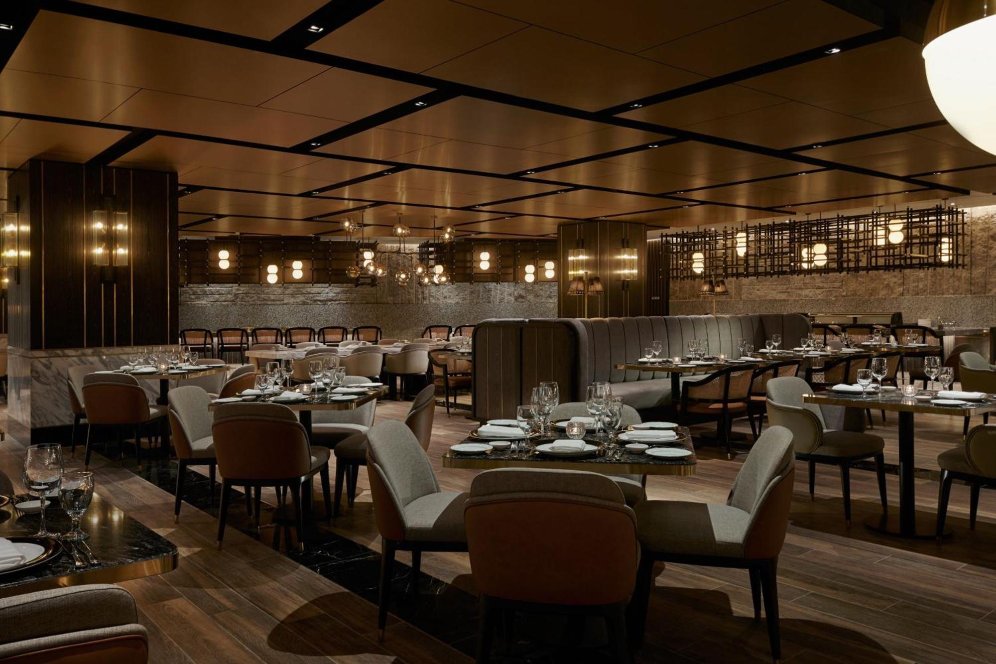 Jw Marriott Kuala Lumpur Hotel Exterior photo The photo depicts an elegant restaurant interior. It features a spacious layout with wooden flooring and a combination of dark and light decor. The seating consists of plush chairs arranged around tables, which are set with cutlery and plates. The ce